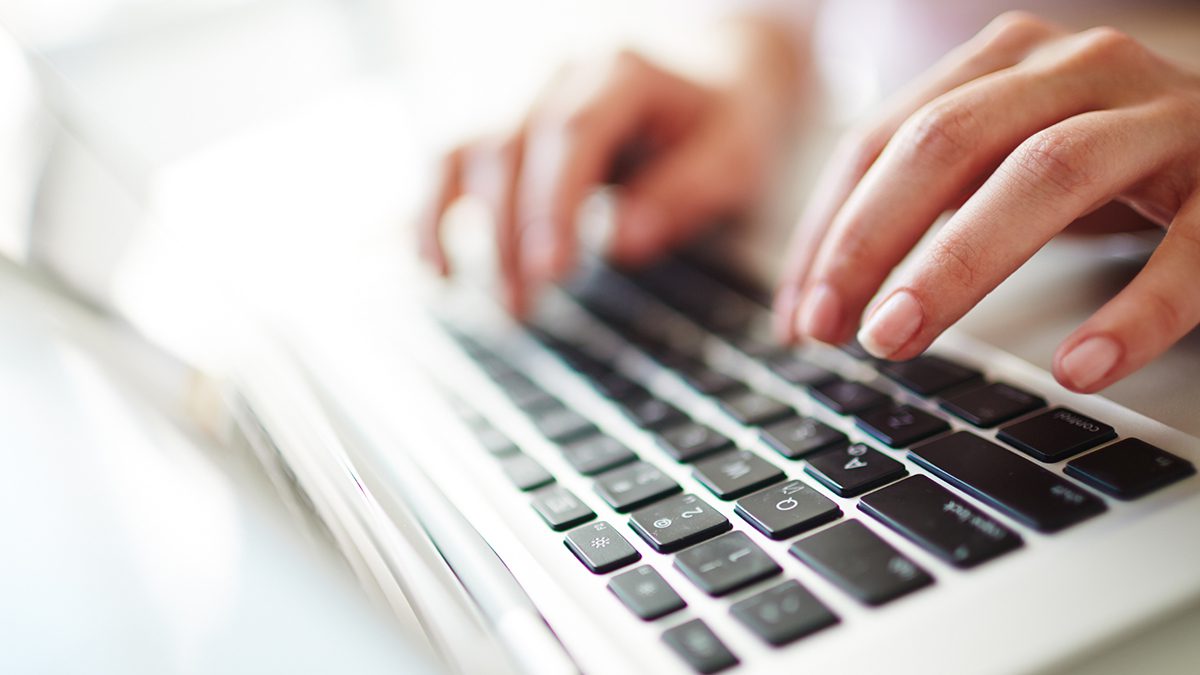 hands typing on a laptop computer keyboard