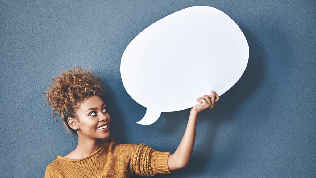 a person holding up a chat bubble