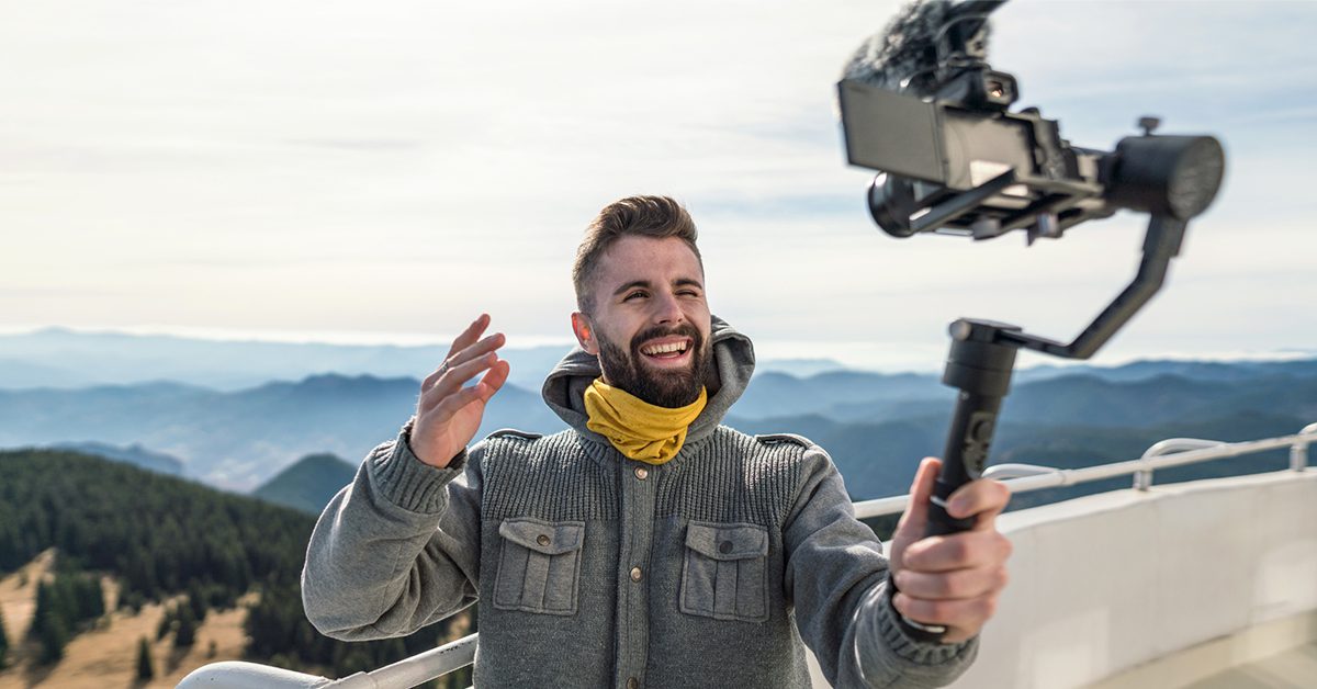 a man filming himself on camera with a selfie stick