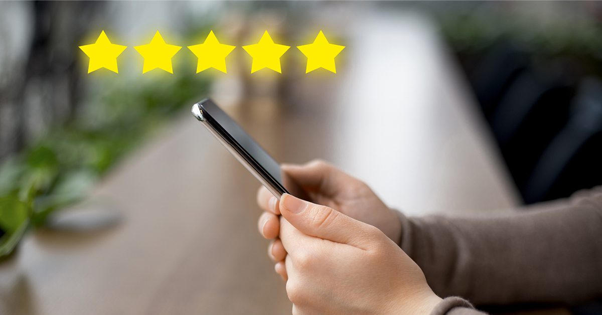 a person holding a cell phone with 5 stars hovering above it