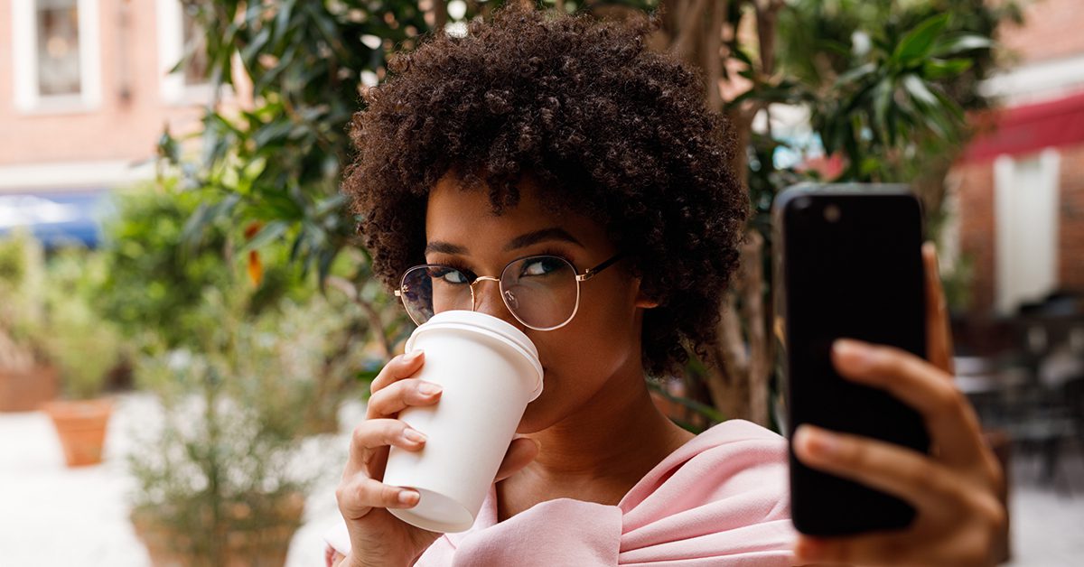 an influencer taking a selfie while drinking coffee